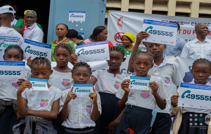 Les élèves de l'EP Ebenga tenant les autocollants du numéro vert