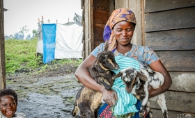 Manelio Semucho, une bénéficiaire de la réinsertion socio-économique, tenant des doublés de la première mise-bas de sa chèvre