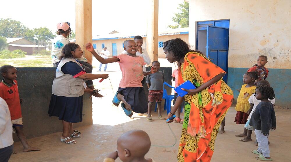 Swaze, une jeune fille de Bunia en train de jouer à la corde avec ses amies à l’espace sûr Amani accompagnée par les assistantes psychosociales.