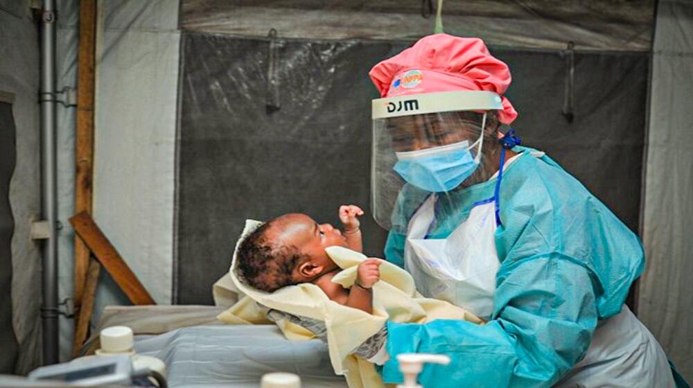 Une sage-femme examine un enfant en appliquant des mesures de prévention et de contrôle des infections (PCI) dans la clinique mobile de Rusayo