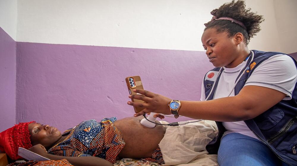 Une sage-femme en pleine séance d'examen d’échographie portable avec smartphone