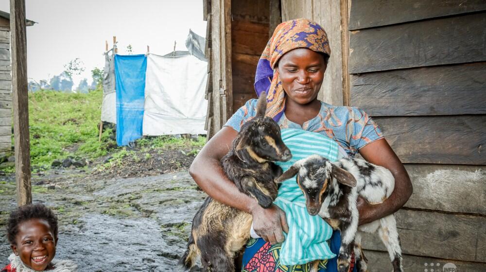 Manelio Semucho, une bénéficiaire de la réinsertion socio-économique, tenant des doublés de la première mise-bas de sa chèvre