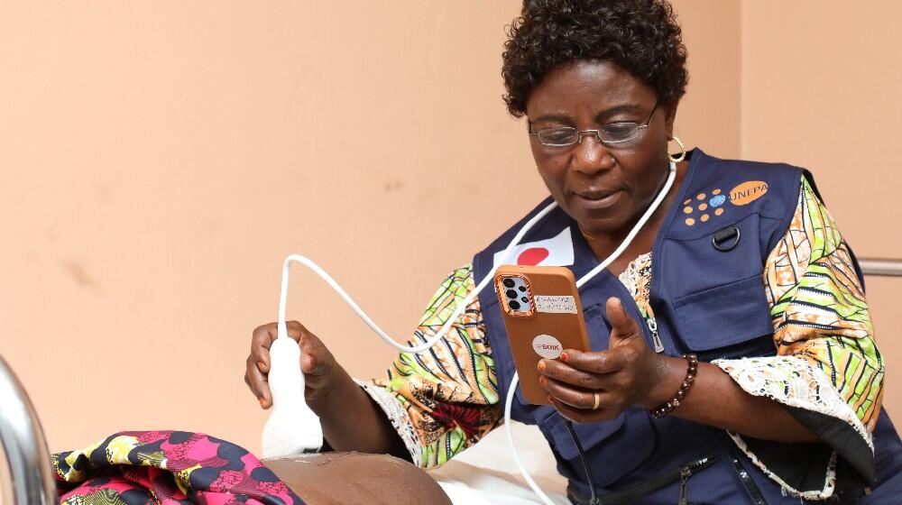  Une sage-femme en pleine séance d'examen d’échographie portable avec smartphone